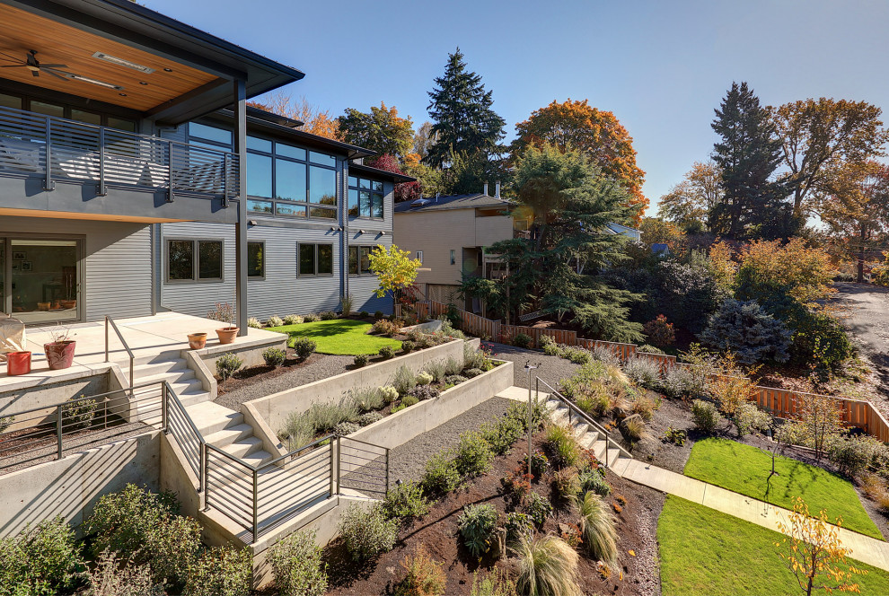 Photo of an expansive contemporary backyard full sun xeriscape in Portland with a retaining wall and concrete pavers.