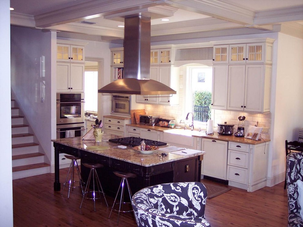 Eat-in kitchen - mid-sized transitional galley medium tone wood floor eat-in kitchen idea with flat-panel cabinets, white cabinets, stainless steel appliances, beige walls and an island