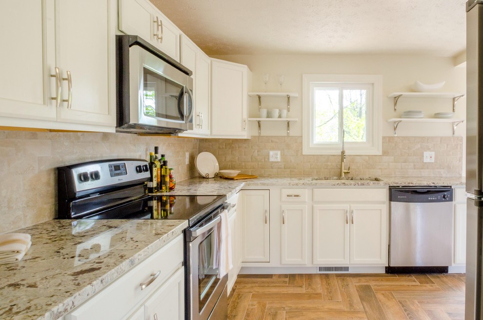 Kitchen - mid-sized transitional u-shaped porcelain tile and brown floor kitchen idea in Cincinnati with an undermount sink, recessed-panel cabinets, white cabinets, granite countertops, beige backsplash, stone tile backsplash, stainless steel appliances and no island