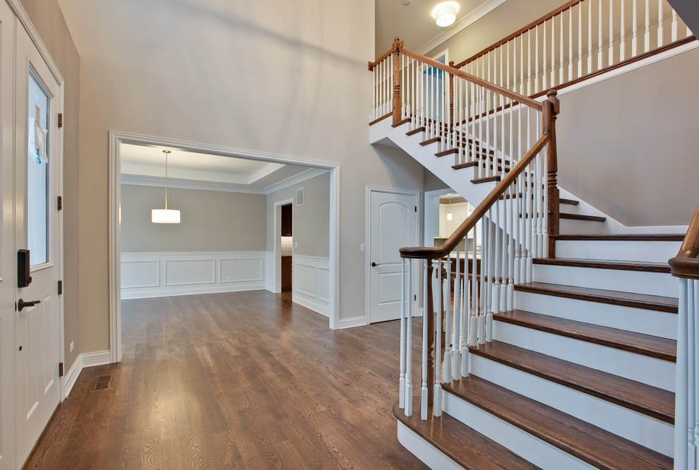 Design ideas for a mid-sized traditional wood curved staircase in Chicago with painted wood risers.