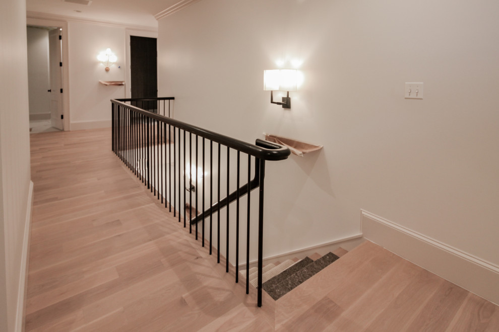 Staircase - large modern wooden u-shaped mixed material railing and wainscoting staircase idea in DC Metro with painted risers