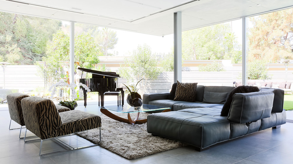 This is an example of a contemporary open concept living room in Los Angeles with a music area, no fireplace, no tv and grey floor.
