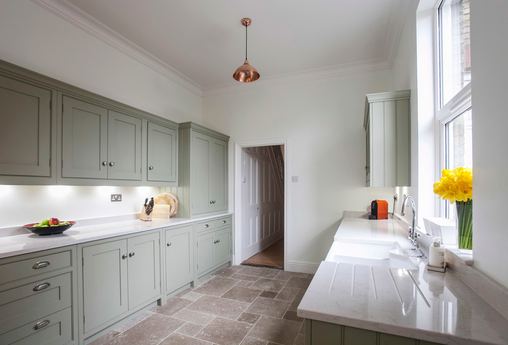 Design ideas for a mid-sized contemporary galley separate kitchen in Kent with a farmhouse sink, shaker cabinets, quartzite benchtops, white splashback, coloured appliances, limestone floors, green cabinets, subway tile splashback and white benchtop.