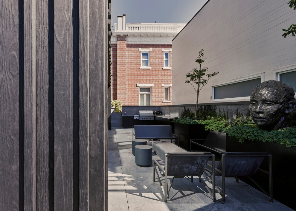 Ejemplo de patio minimalista sin cubierta con jardín de macetas y adoquines de hormigón