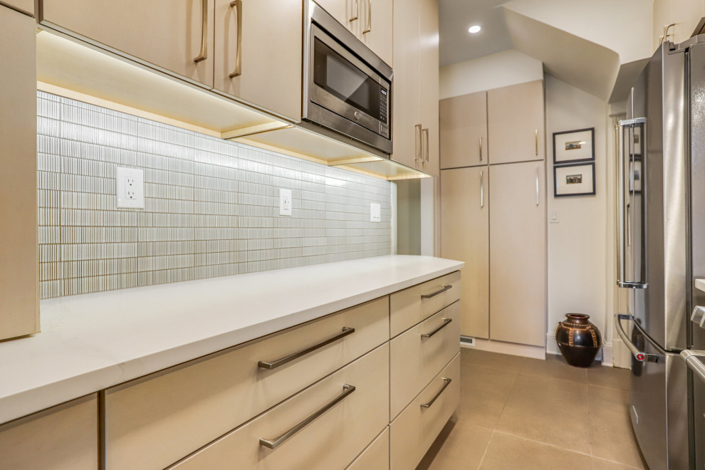 Example of a mid-sized transitional galley kitchen pantry design in DC Metro with a drop-in sink, flat-panel cabinets, light wood cabinets, stainless steel appliances and no island