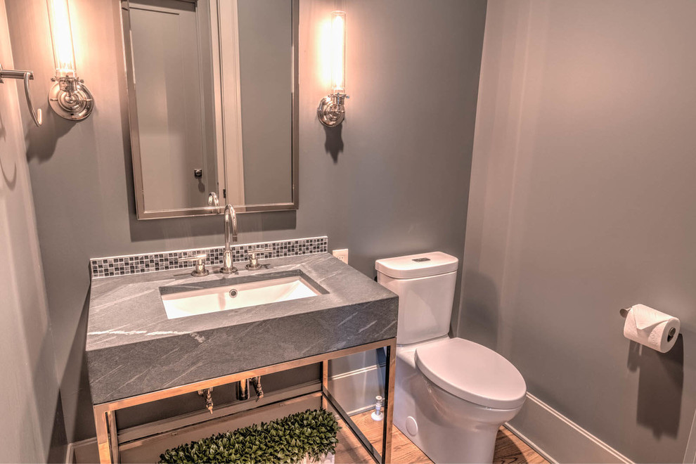 This is an example of a small contemporary powder room in Atlanta with a one-piece toilet, grey walls, light hardwood floors, a console sink and beige floor.