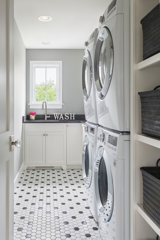 Design ideas for a mid-sized transitional l-shaped dedicated laundry room in Minneapolis with shaker cabinets, white cabinets, quartz benchtops, grey walls, porcelain floors, black benchtop and multi-coloured floor.