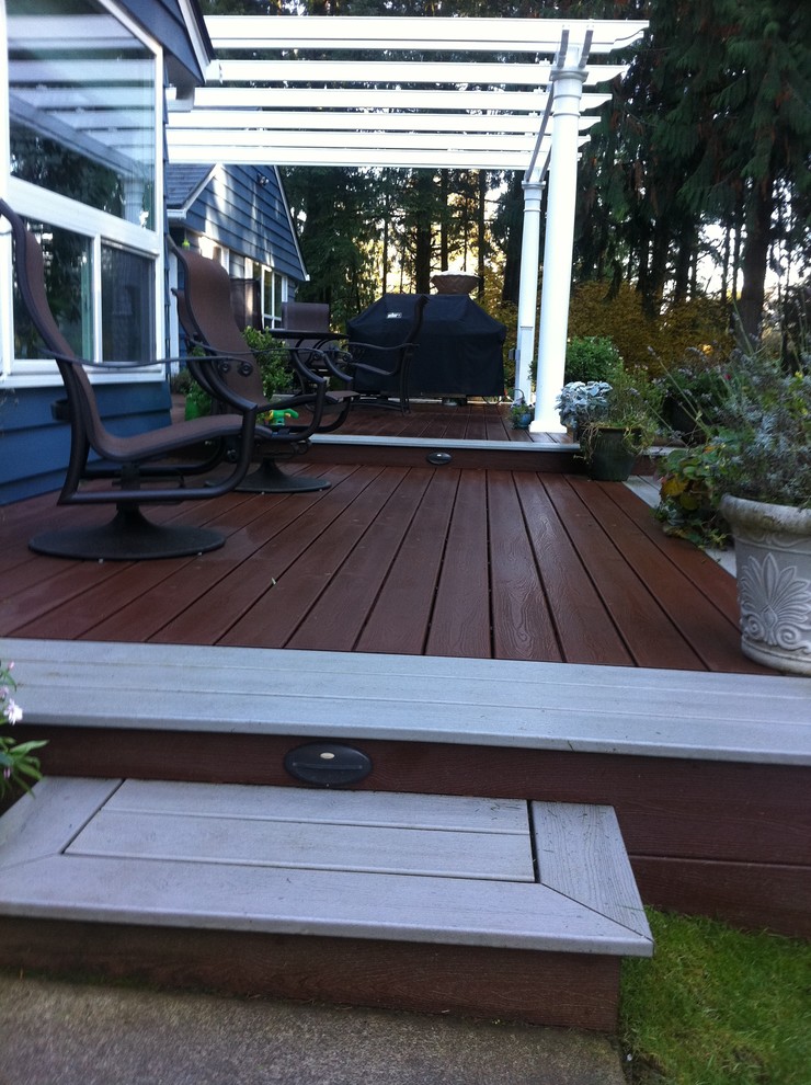 Example of a transitional backyard deck design in Seattle with a pergola