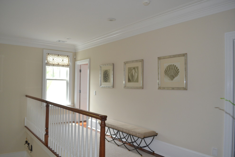 Photo of a large transitional hallway in New York with beige walls and medium hardwood floors.