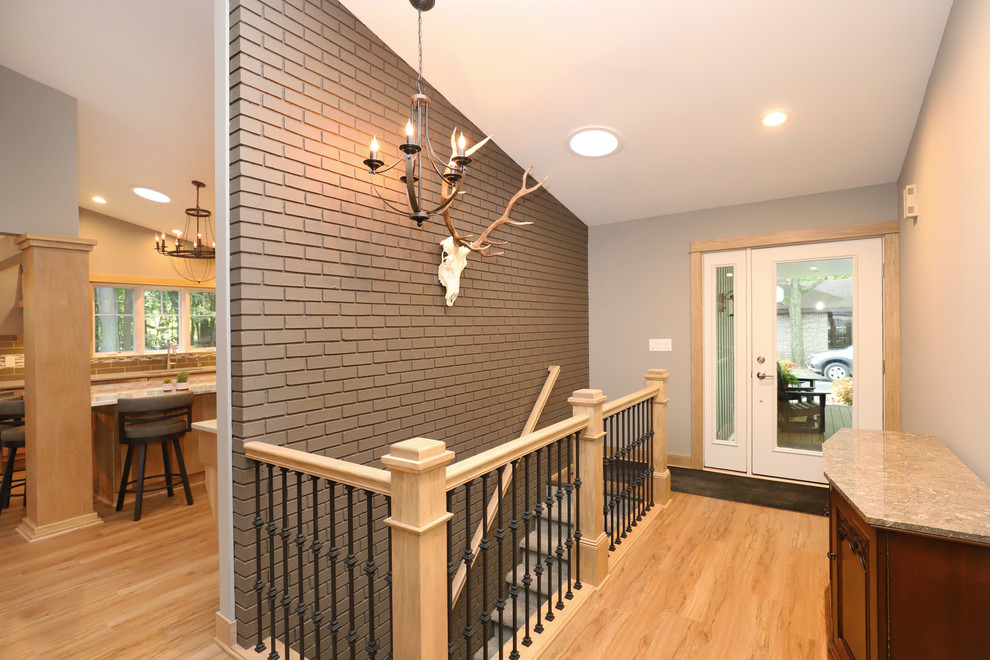 Example of a mid-sized transitional light wood floor and brown floor front door design in Grand Rapids with gray walls and a white front door