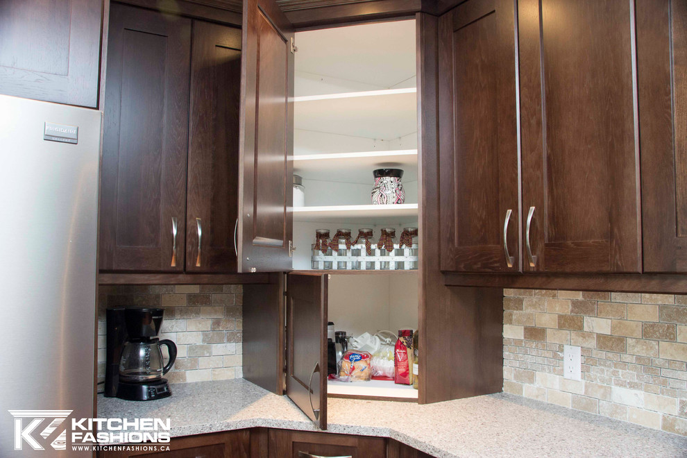 Example of a large transitional u-shaped medium tone wood floor open concept kitchen design with a farmhouse sink, shaker cabinets, dark wood cabinets, quartz countertops, brown backsplash, stone tile backsplash, stainless steel appliances and an island