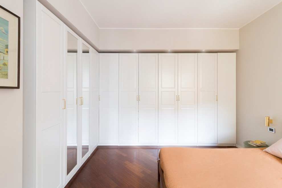 Photo of a large modern master bedroom in Milan with beige walls, dark hardwood floors, brown floor and panelled walls.