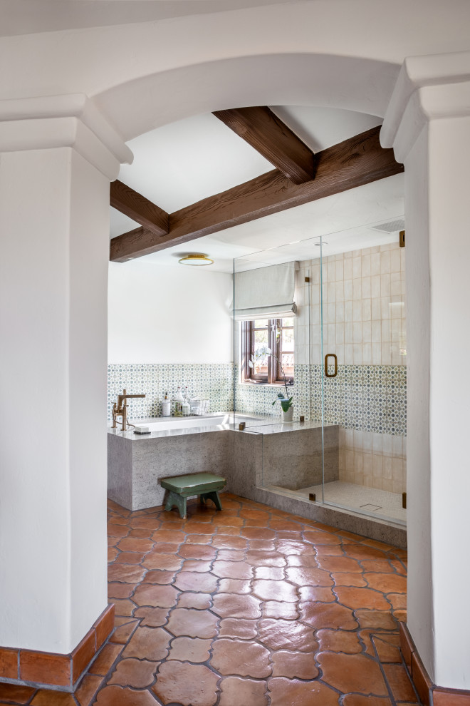 Idées déco pour une grande salle de bain méditerranéenne avec une baignoire encastrée, une douche d'angle, un carrelage vert, des carreaux de porcelaine, un mur rouge, un sol en bois brun, un plan de toilette en quartz, une cabine de douche à porte battante, un plan de toilette gris, meuble-lavabo encastré et poutres apparentes.