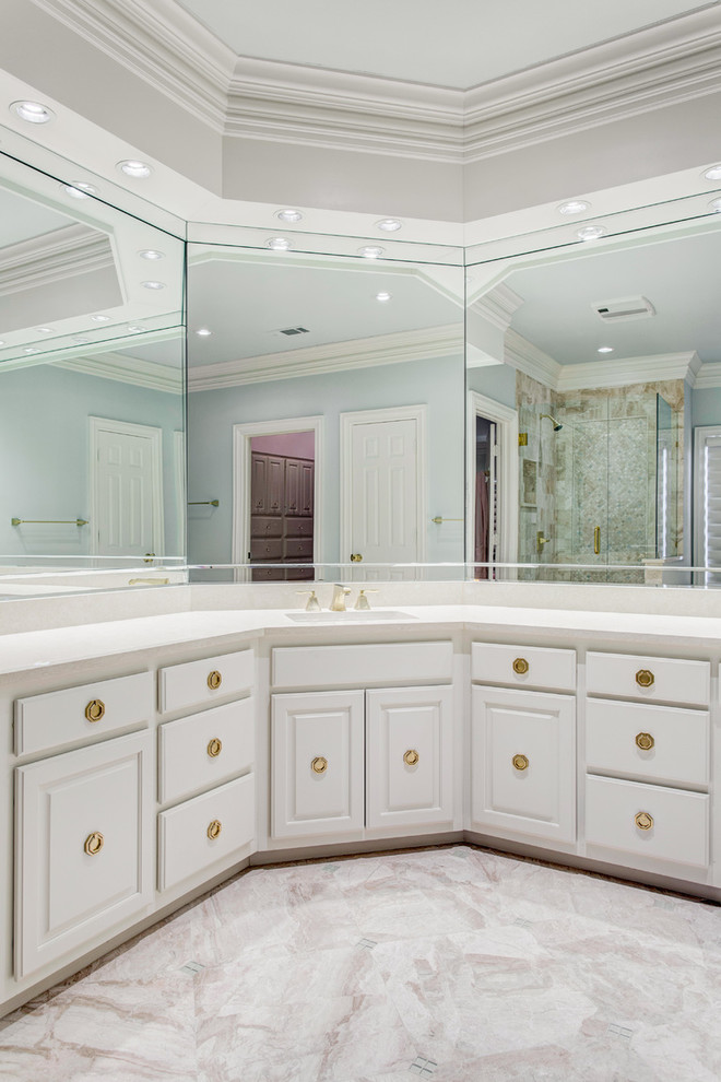 Inspiration for a large traditional master bathroom in Dallas with raised-panel cabinets, white cabinets, a drop-in tub, a corner shower, beige tile, marble, white walls, marble floors, an undermount sink and engineered quartz benchtops.