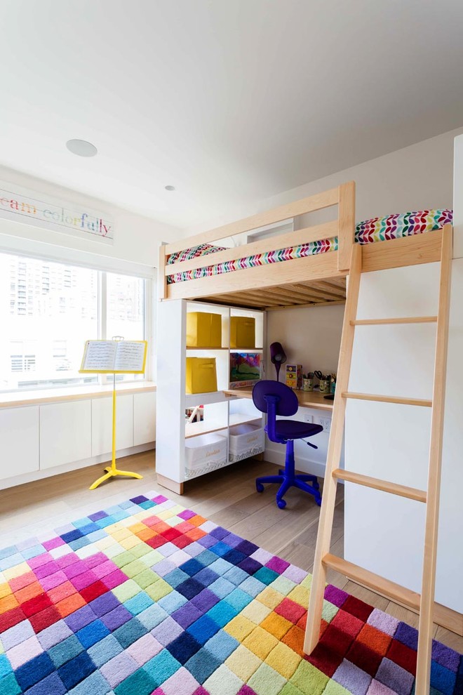 This is an example of a mid-sized scandinavian gender-neutral kids' bedroom for kids 4-10 years old in New York with white walls and light hardwood floors.