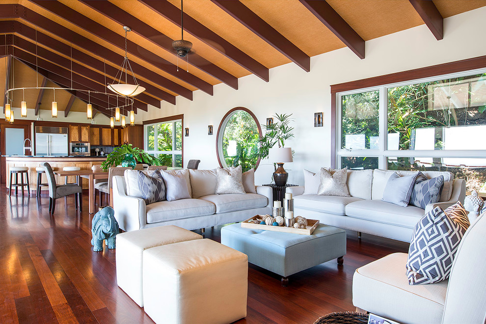 This is an example of a beach style open concept living room in Hawaii with white walls and medium hardwood floors.