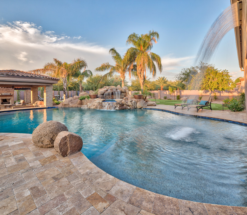 Inspiration for a large mediterranean backyard natural pool in Phoenix with natural stone pavers.