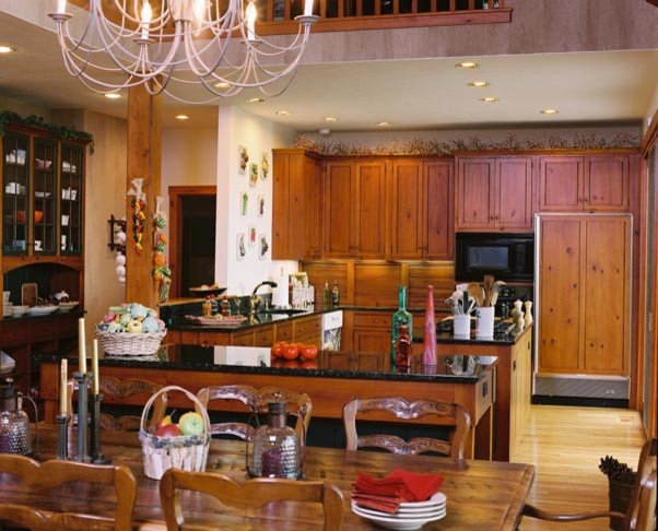 Example of a large l-shaped light wood floor eat-in kitchen design with an undermount sink, shaker cabinets, medium tone wood cabinets, paneled appliances and an island