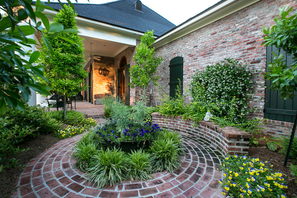 Traditional garden in Dallas with brick pavers and with flowerbed.