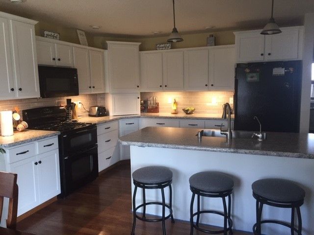 Eat-in kitchen - mid-sized transitional l-shaped eat-in kitchen idea with shaker cabinets, white cabinets and an island