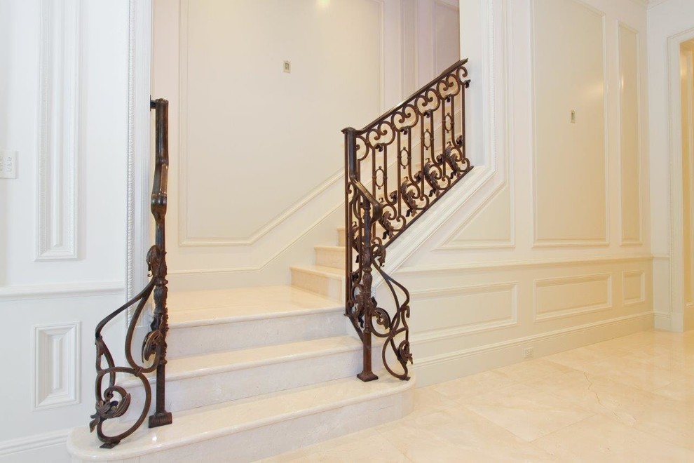 Inspiration for a mid-sized traditional marble l-shaped staircase in Miami with marble risers and metal railing.
