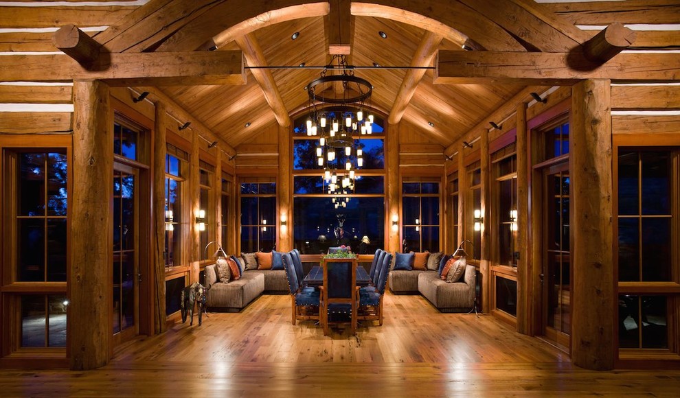 Large mountain style medium tone wood floor and brown floor kitchen/dining room combo photo with brown walls