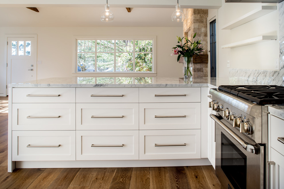 Inspiration for a modern u-shaped open plan kitchen in San Francisco with a farmhouse sink, shaker cabinets, white cabinets, marble benchtops, white splashback, stone slab splashback, stainless steel appliances, medium hardwood floors and a peninsula.