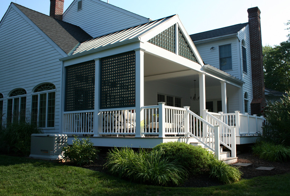 Inspiration for a large traditional backyard screened-in verandah in New York with decking and a roof extension.