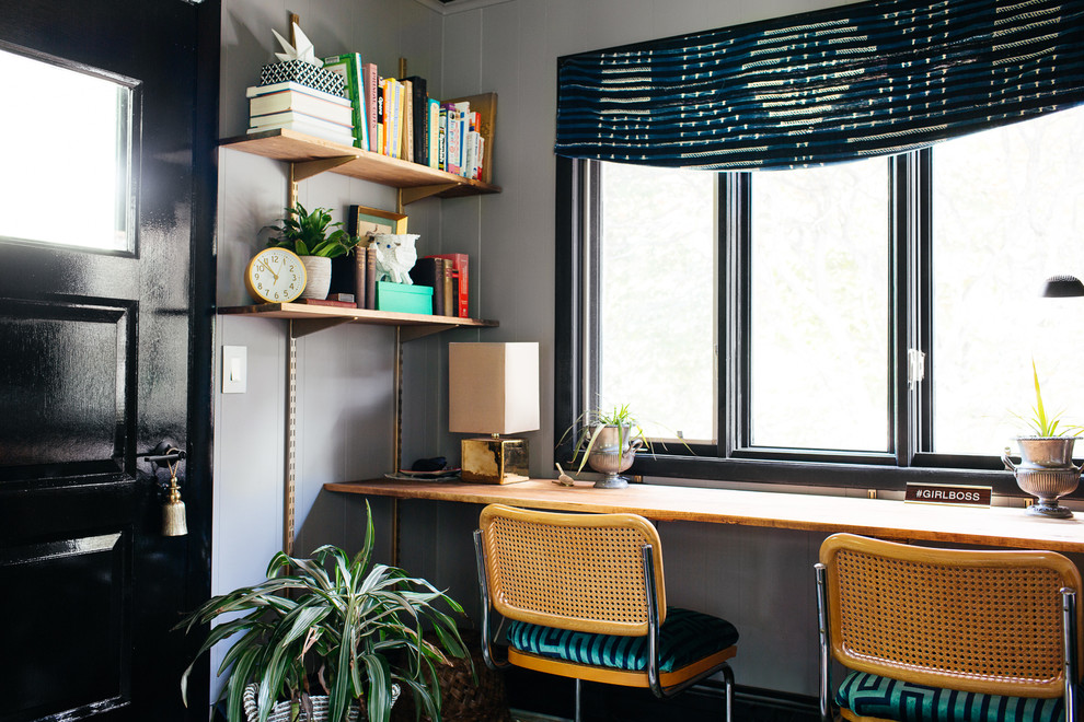 Inspiration for a mid-sized midcentury home office in New York with grey walls, dark hardwood floors, no fireplace, a built-in desk and brown floor.