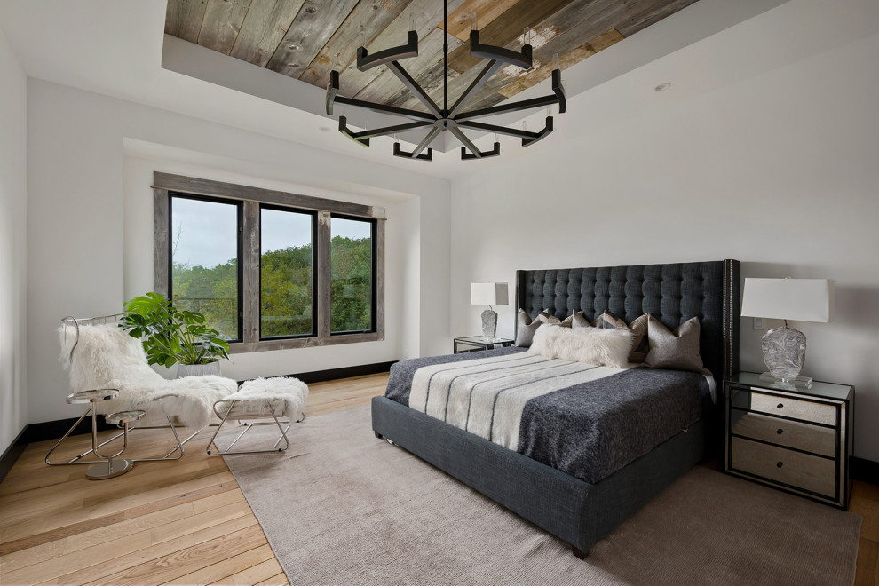 Contemporary bedroom in Kansas City with white walls, light hardwood floors, beige floor, recessed and wood.