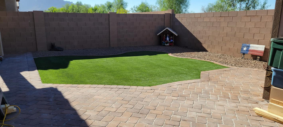 Ispirazione per un giardino xeriscape stile americano esposto in pieno sole dietro casa con un focolare, sassi e rocce, pavimentazioni in mattoni e recinzione in pietra