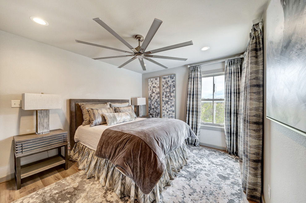 This is an example of a large contemporary guest bedroom in Dallas with grey walls, medium hardwood floors and brown floor.
