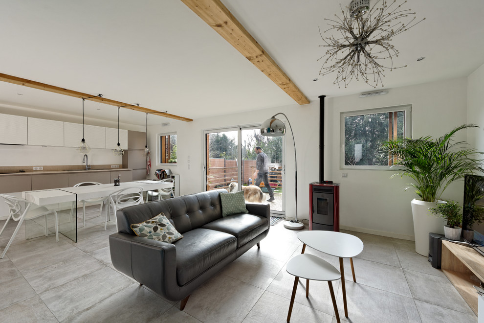 Exemple d'une salle de séjour tendance de taille moyenne et ouverte avec un mur blanc, un sol en carrelage de céramique, un poêle à bois, un téléviseur indépendant et un sol gris.