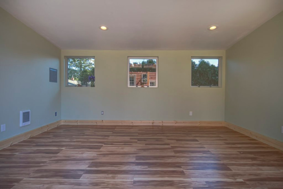 Mittelgroßer Mid-Century Yogaraum mit weißer Wandfarbe, braunem Holzboden und braunem Boden in Portland