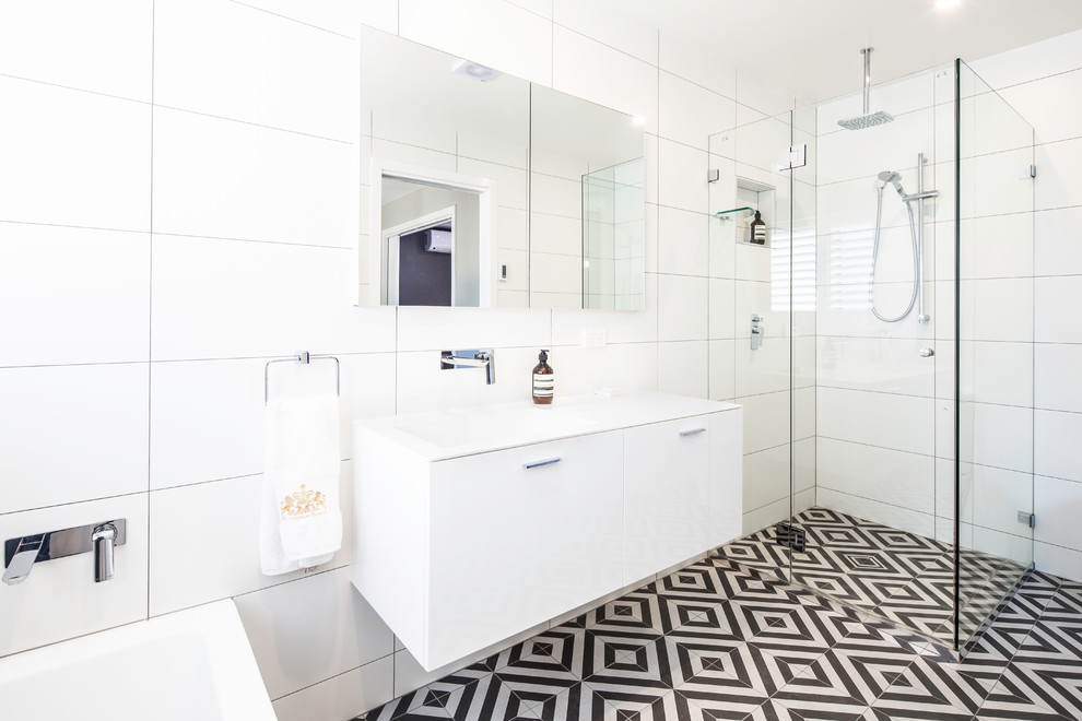 Inspiration for a mid-sized contemporary master bathroom in Brisbane with flat-panel cabinets, white cabinets, a drop-in tub, a corner shower, a one-piece toilet, black and white tile, porcelain tile, yellow walls, porcelain floors, an integrated sink and solid surface benchtops.