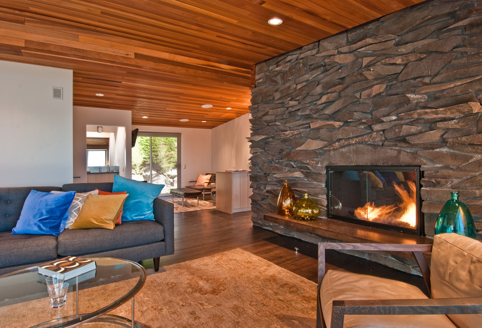 Inspiration for a midcentury living room in Seattle with a standard fireplace and a stone fireplace surround.