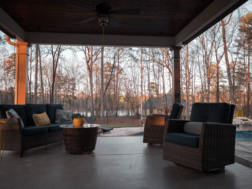 This is an example of a mid-sized country backyard verandah in Atlanta with concrete slab and a roof extension.