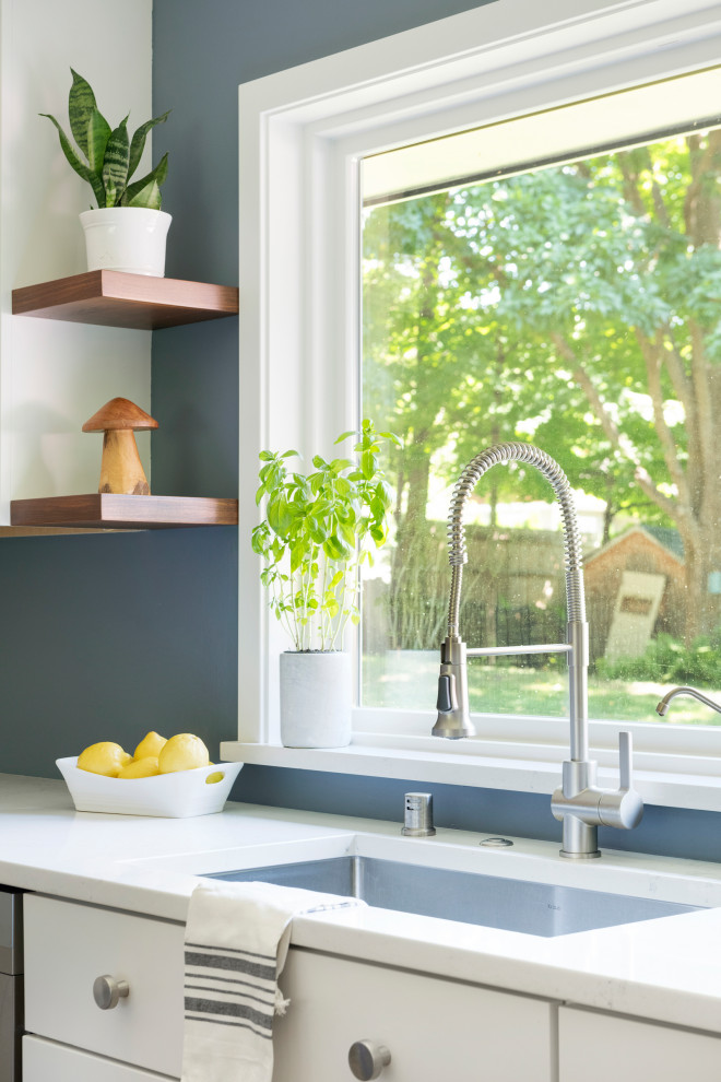 Example of a large transitional l-shaped vinyl floor eat-in kitchen design in Minneapolis with an undermount sink, shaker cabinets, white cabinets, quartz countertops, stainless steel appliances, an island and white countertops