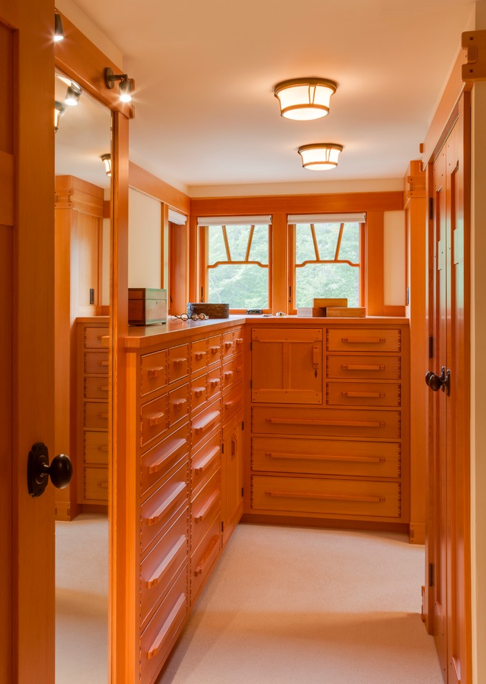 Design ideas for a mid-sized arts and crafts gender-neutral dressing room in Portland Maine with flat-panel cabinets, medium wood cabinets, carpet and beige floor.