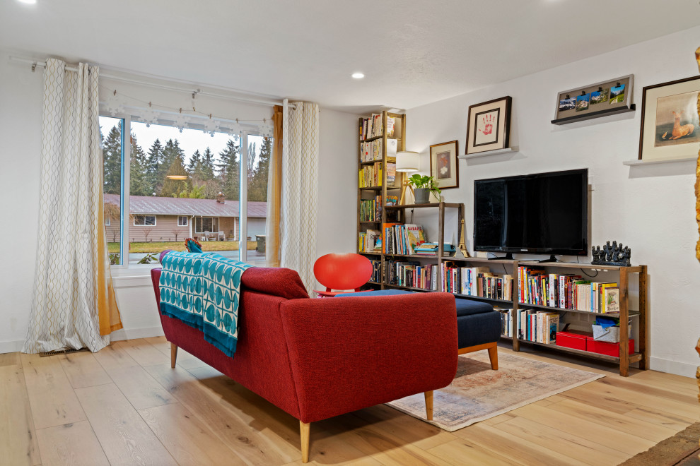 Eklektisk inredning av ett litet separat vardagsrum, med ett bibliotek, vita väggar, vinylgolv, en fristående TV, beiget golv och en standard öppen spis