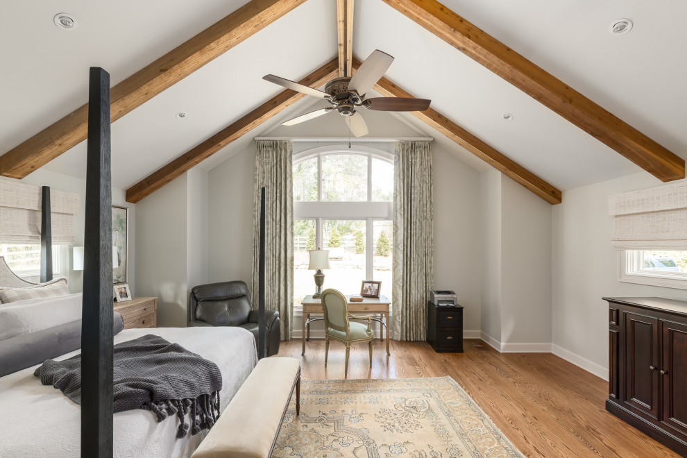 Expansive traditional master bedroom in Atlanta with multi-coloured walls, dark hardwood floors, a standard fireplace, a stone fireplace surround, brown floor, exposed beam and panelled walls.