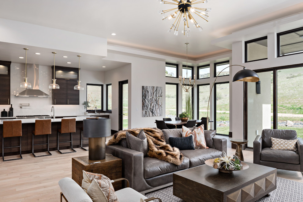 Contemporary open concept living room in Boise with white walls, light hardwood floors and beige floor.