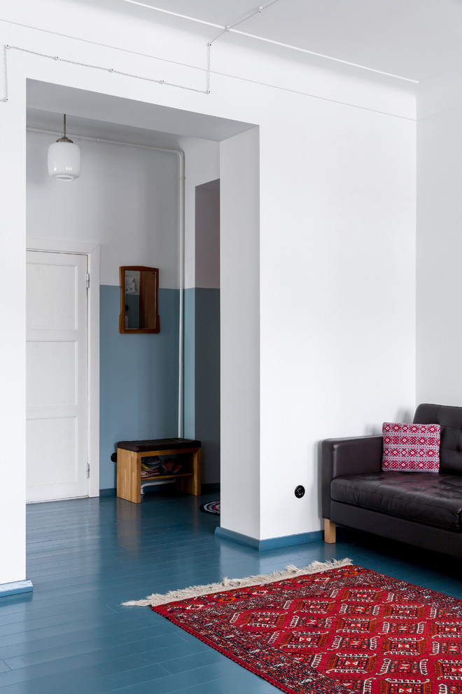 На фото: гостиная комната в стиле ретро с белыми стенами, деревянным полом и синим полом