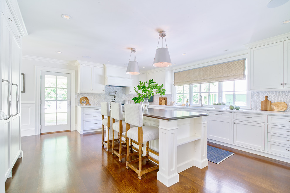 Enclosed kitchen - large transitional u-shaped dark wood floor and brown floor enclosed kitchen idea in Boston with recessed-panel cabinets, white cabinets, granite countertops, an island, an undermount sink, gray backsplash, paneled appliances and gray countertops