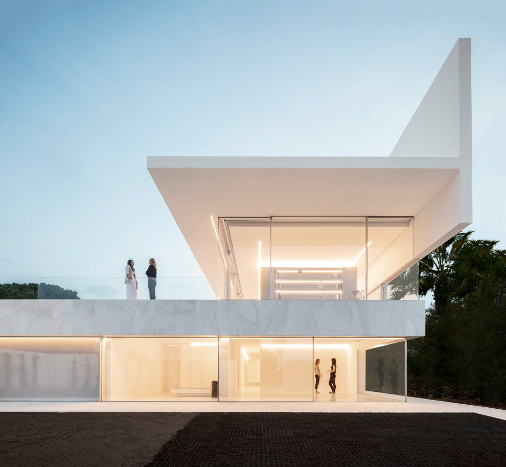 Идея дизайна: огромный, двухэтажный, белый частный загородный дом в стиле модернизм с плоской крышей и белой крышей