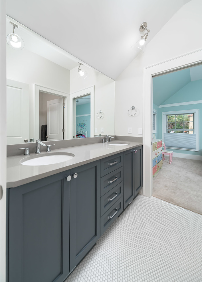 Alcove shower - small transitional kids' gray tile and ceramic tile ceramic tile and white floor alcove shower idea with shaker cabinets, blue cabinets, a two-piece toilet, gray walls, an undermount sink, quartz countertops and a hinged shower door