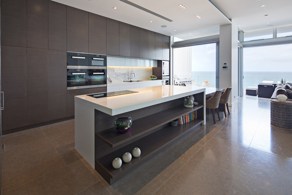 This is an example of an expansive contemporary open plan kitchen in Sydney with an undermount sink, dark wood cabinets, quartz benchtops, white splashback, stone slab splashback, marble floors, with island and flat-panel cabinets.