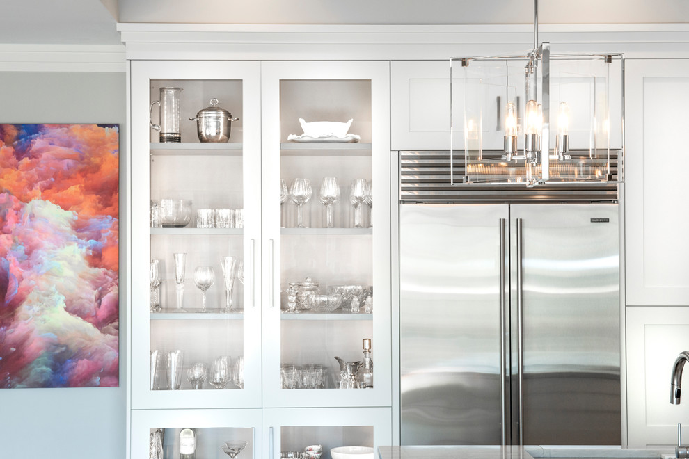 Open concept kitchen - large transitional medium tone wood floor and brown floor open concept kitchen idea with an undermount sink, recessed-panel cabinets, white cabinets, quartzite countertops, brown backsplash, ceramic backsplash, stainless steel appliances, an island and white countertops