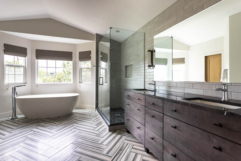 Large transitional master gray tile and porcelain tile marble floor, multicolored floor, double-sink and vaulted ceiling bathroom photo in Denver with flat-panel cabinets, dark wood cabinets, a two-piece toilet, white walls, an undermount sink, marble countertops, a hinged shower door, gray countertops and a freestanding vanity