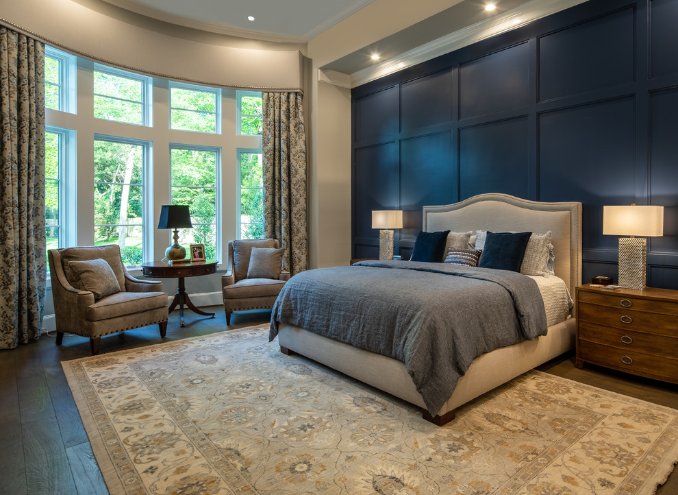 Photo of an expansive transitional master bedroom in Houston with blue walls, dark hardwood floors and brown floor.